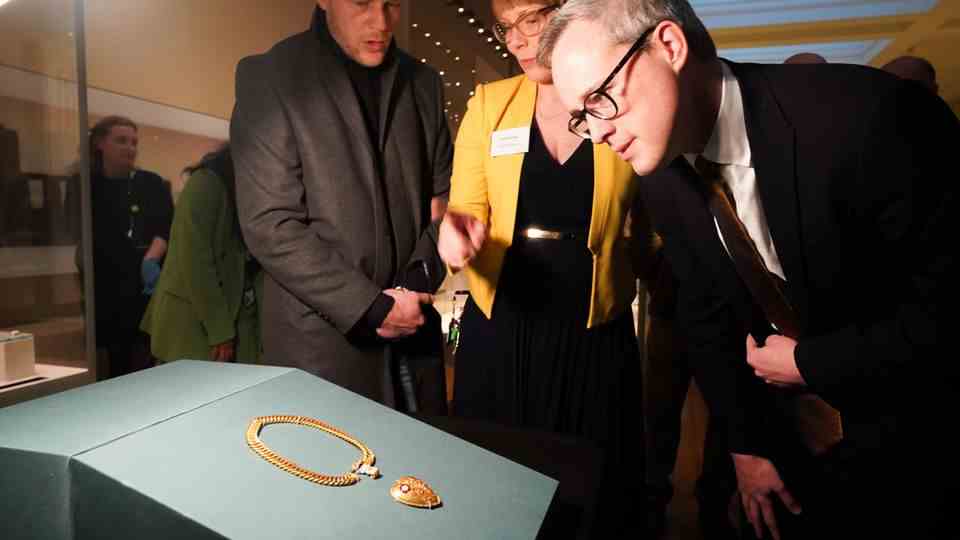 Finder Charlie Clarke (left) looks at the chain in London's British Museum
