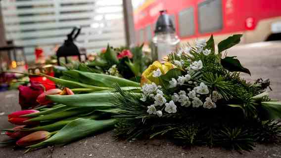 Candles and flowers stand or lie in a bus shelter at Brokstedt station.  Two young people were killed and others injured in a knife attack on a regional train from Kiel to Hamburg on January 25, 2023 in Brokstedt.  © picture alliance/dpa Photo: Daniel Bockwoldt