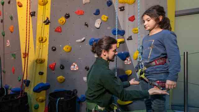 Inclusive sports offer: Safety first: Before climbing, Andreas Schwanengel and Jasmine check whether the harness is sitting correctly.