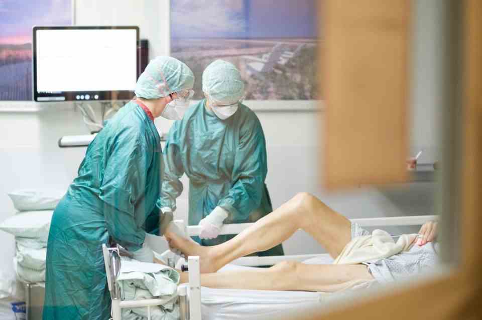 Intensivpflegerinnen versorgen auf der Intensivstation einen an Covid-19 erkrankten Patienten