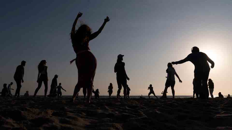 Menschen tanzen bei einem Ecstatic Dance-Event am Strand