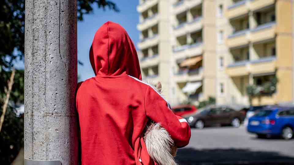 Child poverty in Germany: child stands in front of a block of flats (symbolic image)