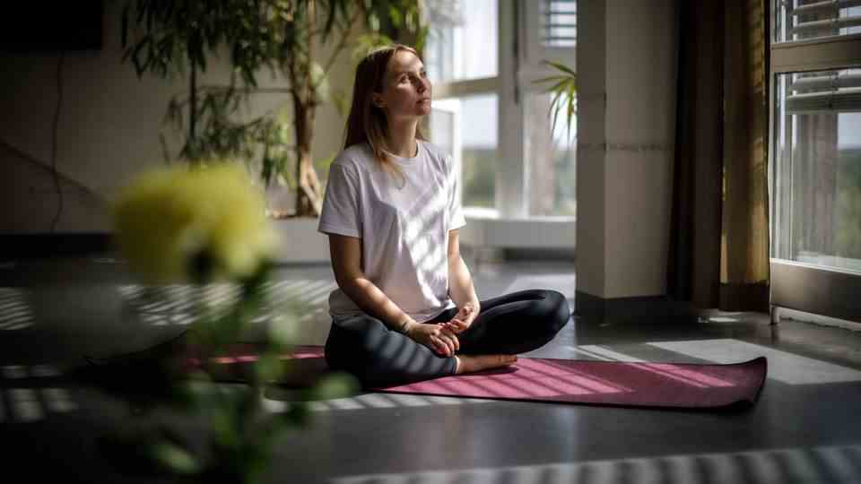 The psychologist Inge Maria Hahne sits on a yoga mat in the open psychosis ward of the Berlin Charité