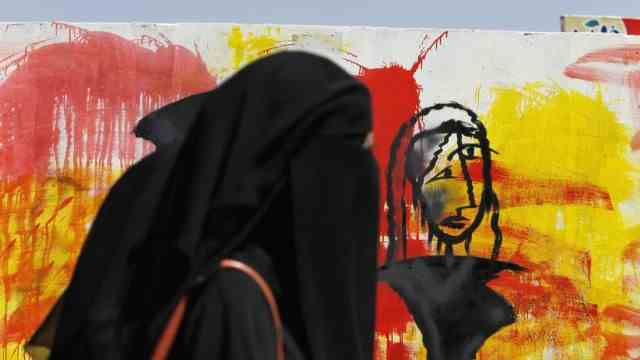 Women in Yemen: Only the graffiti against the civil war is colorful in this street scene in Yemen's capital.