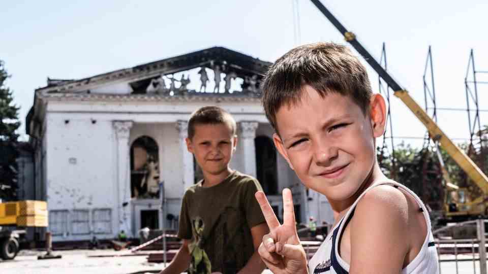 Zwei Jungen spielen vor einem zerstörten Theater