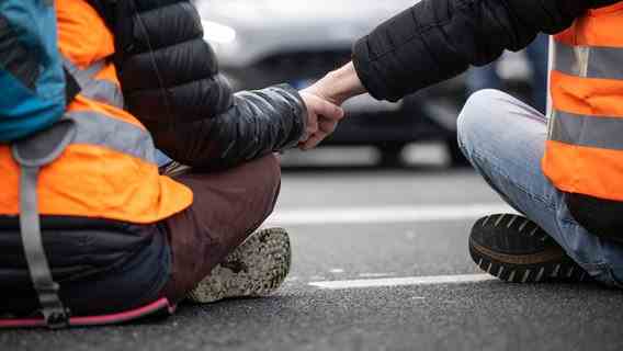 Group climate activists "last generation" taped their hands together to block a road.  © Bernd Thissen/dpa 