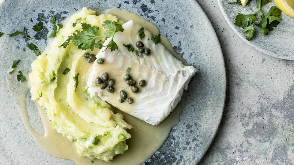 Blue plates feature cod with caper sauce and mashed potatoes, and lemon wedges