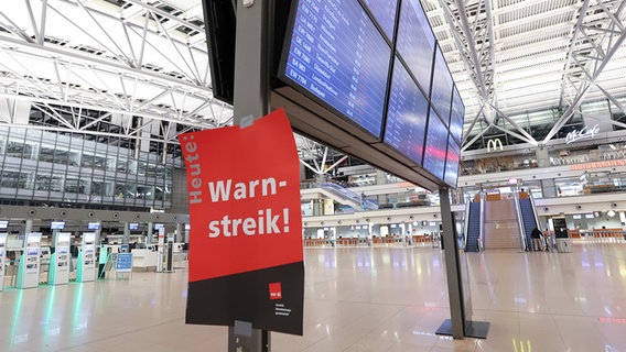 A poster with the inscription "warning strike!" sticks to the display board in the empty Terminal 1. © picture alliance/dpa Photo: Bodo Marks