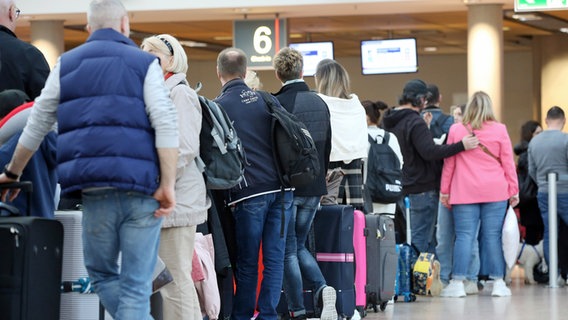 Travelers are queuing at a check-in counter at Hamburg Airport © dpa-Bildfunk Photo: Bodo Marks