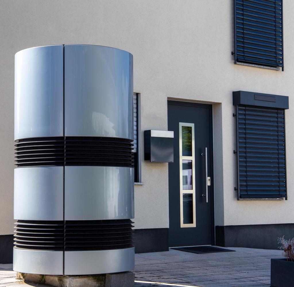 Air and water heat pump in front of a new residential building