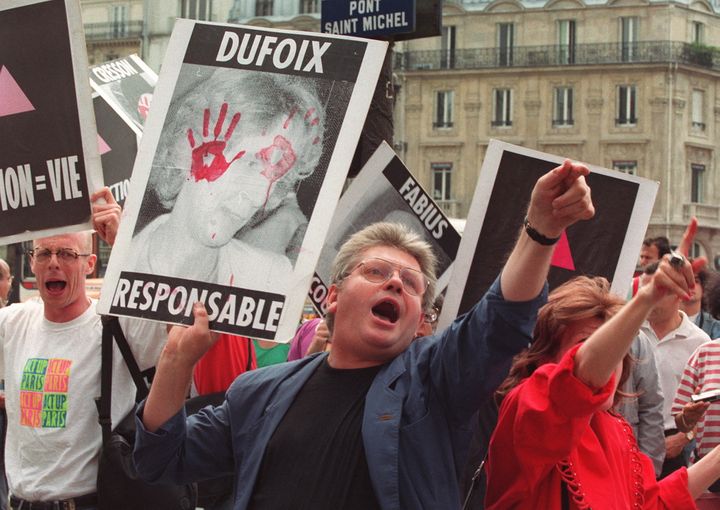 Des membres de l'association Act Up crient des slogans au moment du procès du sang contaminé, à Paris le 24 juillet 1992. (PIERRE BOUSSEL / AFP)