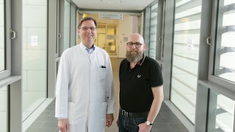 Marc Franke und Dr. Jensen stehen in einem Gang der Uniklinik Düsseldorf.