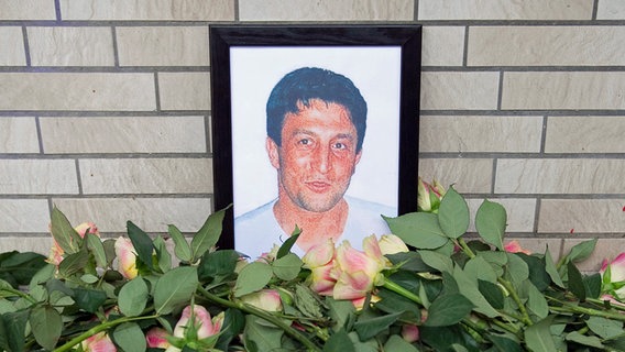 Roses lie in front of the framed picture of the NSU victim Süleyman Tasköprü © picture alliance / dpa Photo: Axel Heimken
