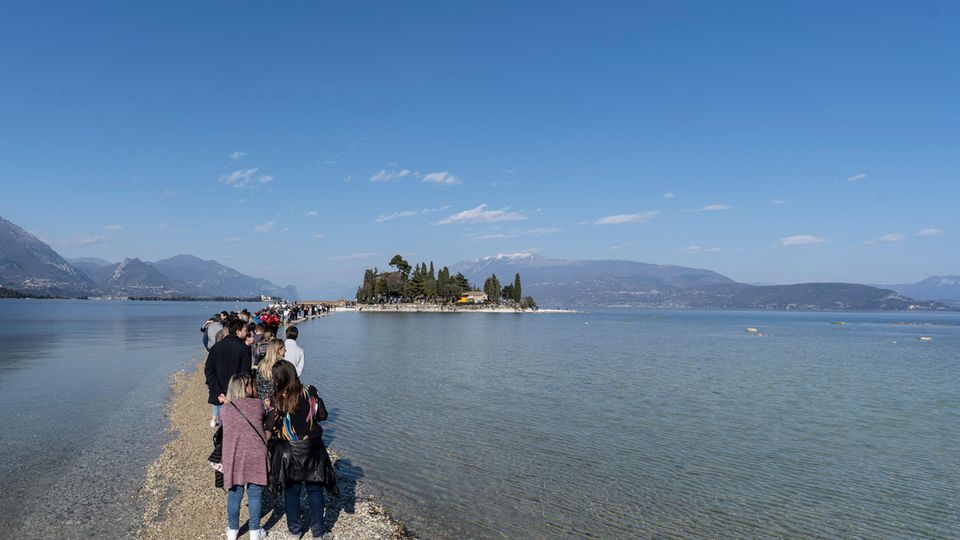 People walk through Lake Garda