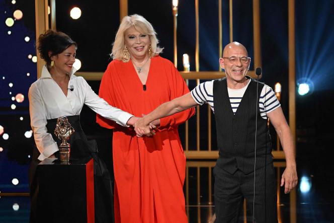 Christian Hecq holds the hand of Valérie Lessort, under the eyes of Amanda Lear, during the 34th Molières ceremony, on April 24, 2023, at the Théâtre de Paris.