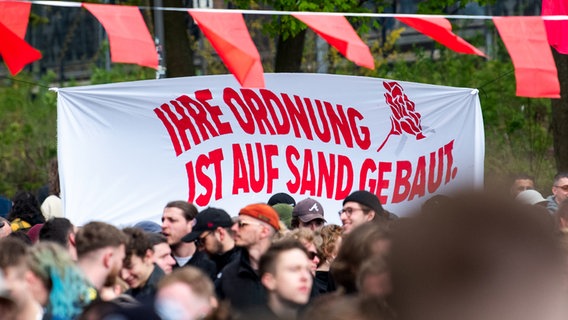 Participants of the extreme left "class party" stand in the Schanzenviertel and hold a banner with the inscription "Their order is built on sand".  © dpa Photo: Daniel Bockwoldt