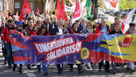 "Unbroken solidarity" is written on a banner behind which the participants of a trade union demonstration on May 1, 2023 in Hamburg are walking.  © picture alliance / dpa Photo: Marcus Brandt