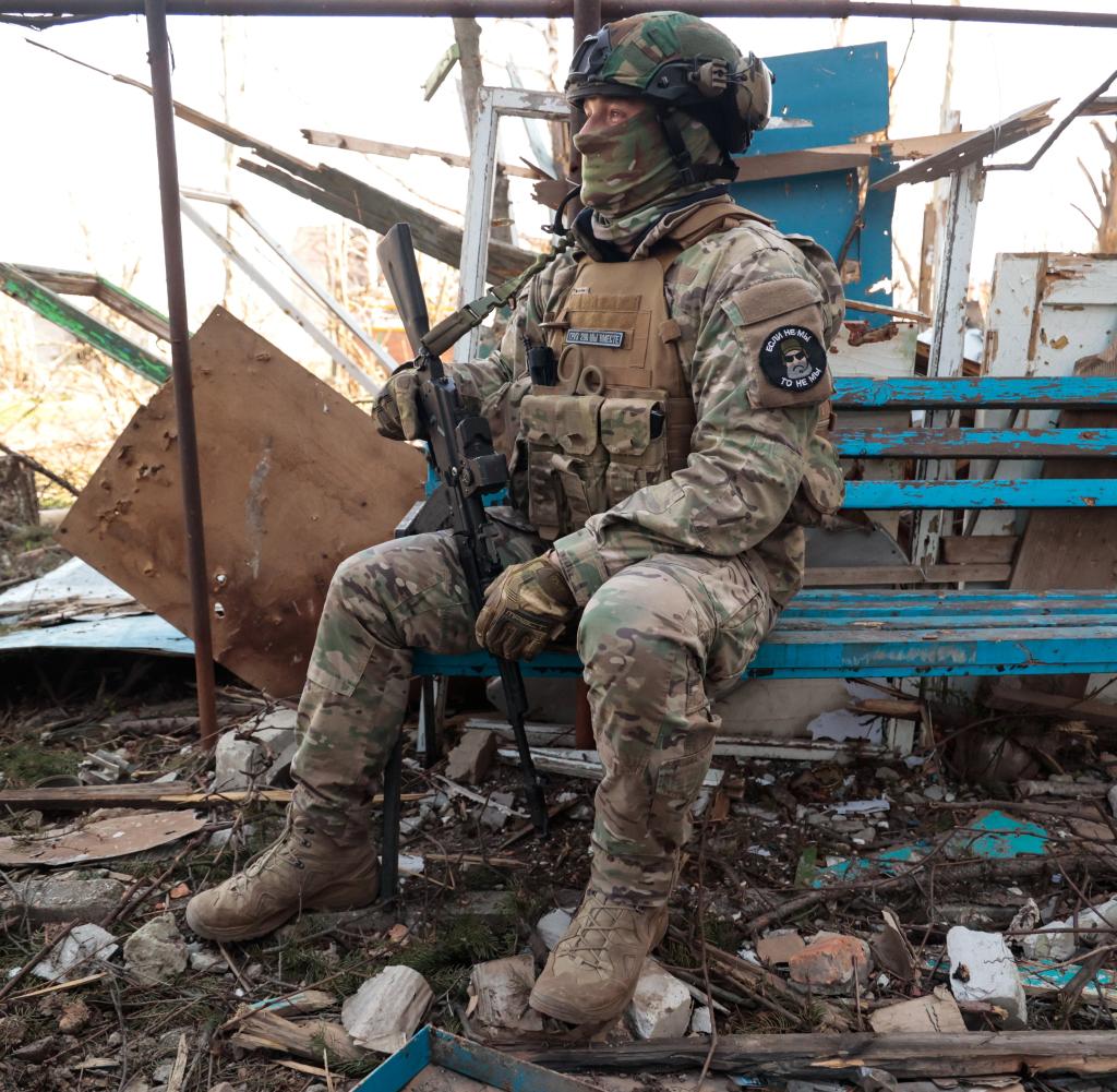 Dieses Foto zeigt laut Staatsagentur Tass einen Soldaten der Wagner-Gruppe vor einem beschädigten Gebäude in Bachmut