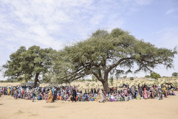 Des réfugiés soudanais à Koufroun (Tchad) se rassemblent pour recevoir de la nourriture, le 30 avril 2023. (GUEIPEUR DENIS SASSOU / AFP)