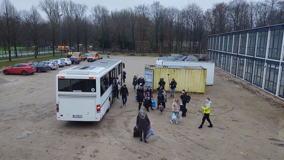 A group of people get off a bus.  © NDR Photo: Peer-Axel Kroeske