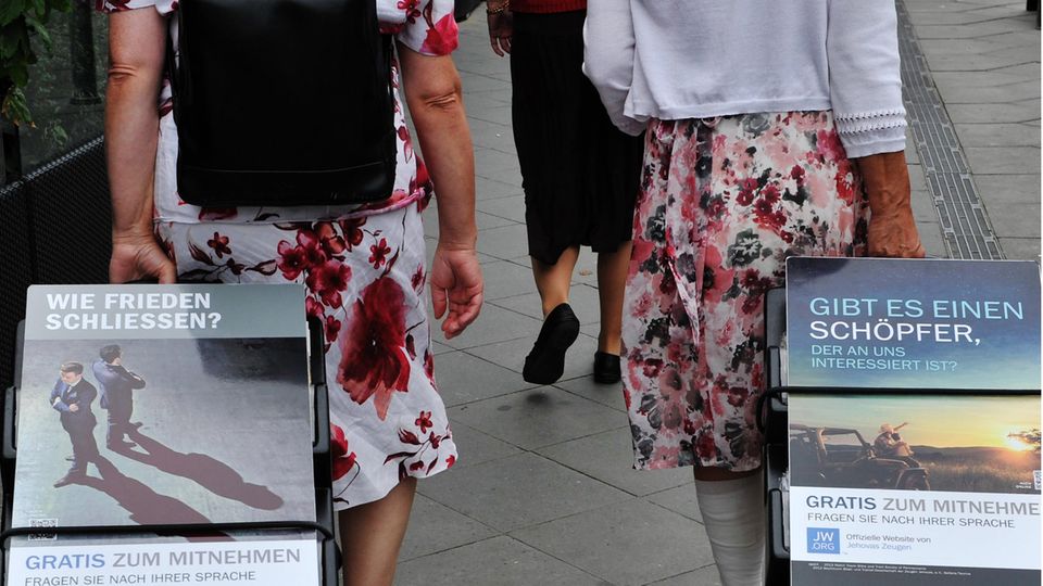 A well-known picture: Two followers of Jehovah's Witnesses pull trolleys with information brochures behind them.