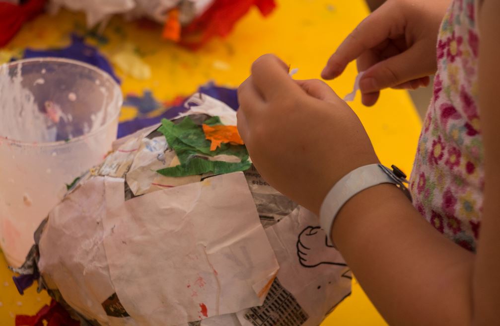 Child Making A Pinata With Paper Mache
