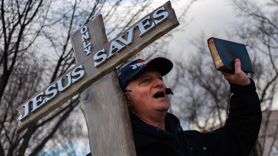 A man protests with a cross and a Bible at the "March for Life" in Washington D.C., United States