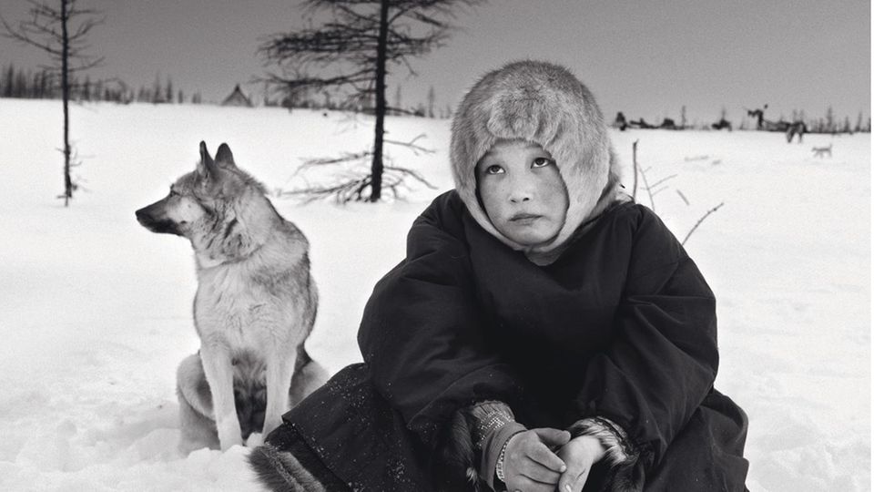 Siberia, 2016: Oksana, a young girl, rests at her campsite in the Arctic.  She belongs to the indigenous Nenets people, who roam the tundra with herds of reindeer