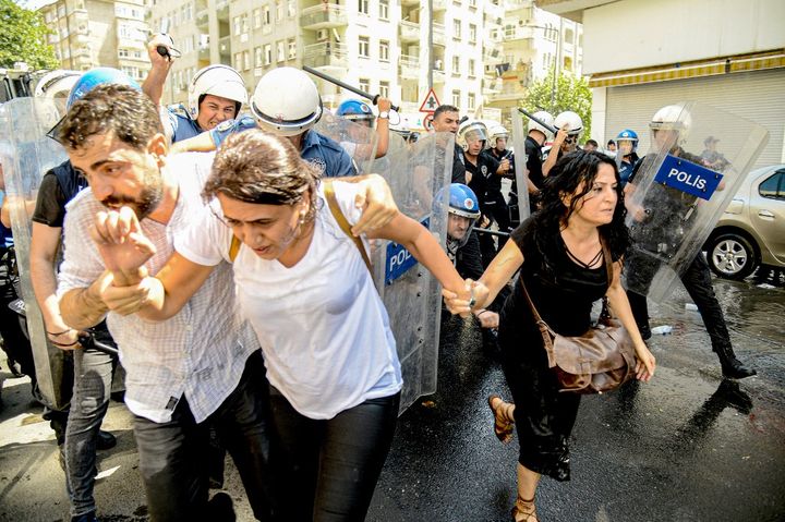 La députée du Parti démocratique des peuples (HDP) Feleknas Uca fuit la police anti-émeute turque lors d'une manifestation à Diyarbakir, le 20 août 2019, contre le remplacement des maires kurdes dans trois villes. (ILYAS AKENGIN / AFP)