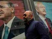 Ein Mann läuft an einem Bild von Recep Tayyip Erdogan und Kemal Kılıçdaroğlu vorbei.