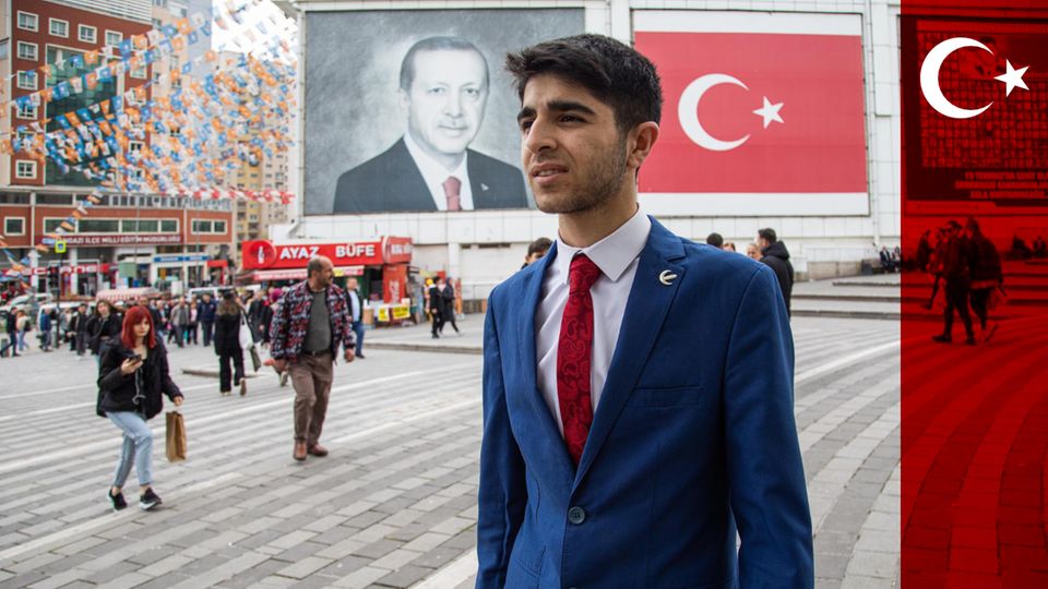 Young man in front of Turkey flag and Erdogan portrait