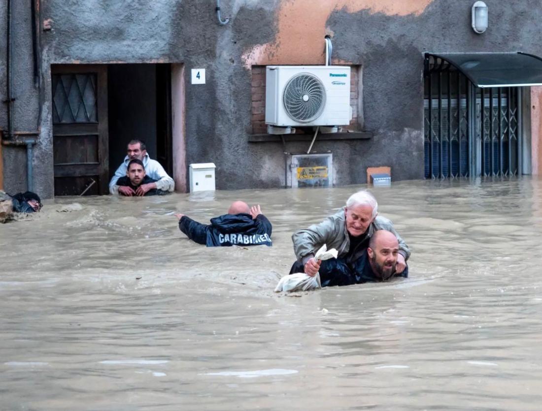After severe flooding, carabinieri carry local residents on their backs through the flooded streets of Faenza.  