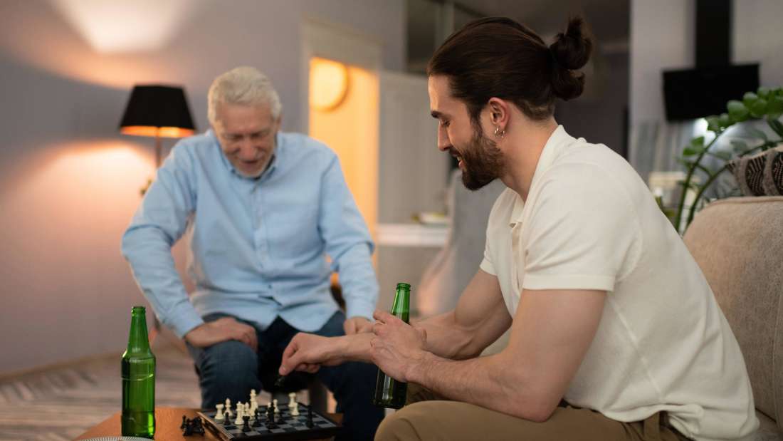 Young and elderly man play chess