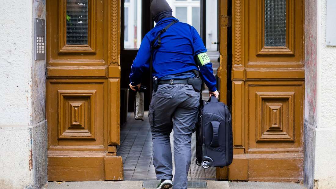 A police officer goes into a house entrance during a house search in Berlin-Kreuzberg. 