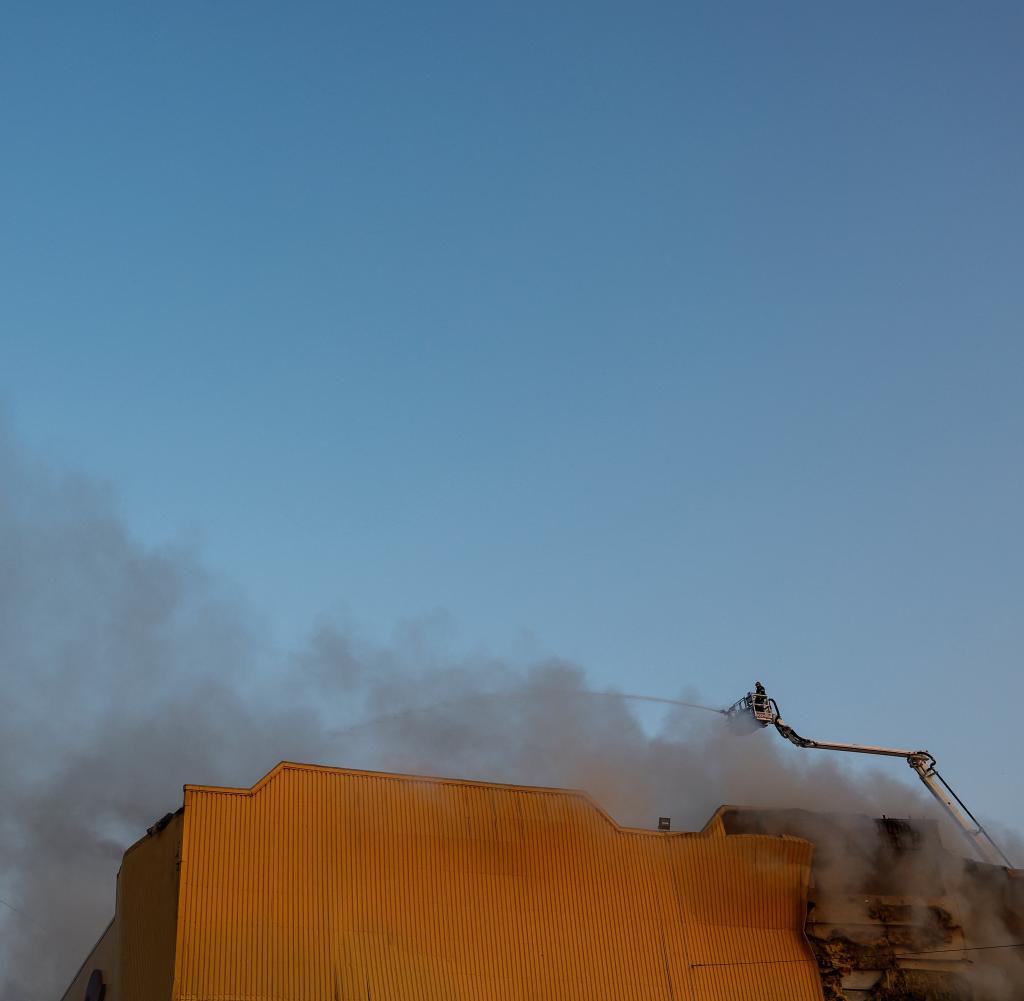 Feuerwehrleute arbeiten in Kiew an einer Tabakfabrik, die bei einem russischen Drohnenangriff beschädigt wurde