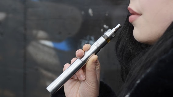 A woman smokes an e-cigarette.  © tunedin - Fotolia Photo: Bernd Friedel