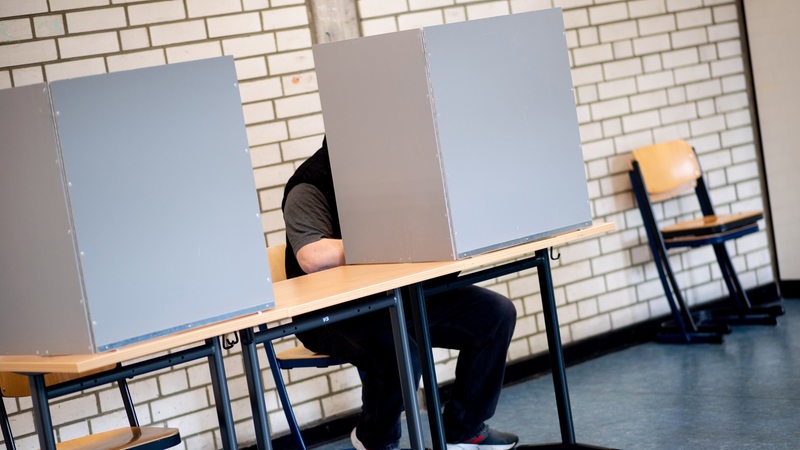 A citizen sits in a voting booth in a school classroom where there is a polling station for the citizenship election and fills in his ballot.  In the federal state of Bremen, the 21st election to the Bremen state parliament as well as local elections in Bremen and Bremerhaven are taking place.