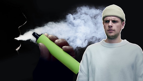 A man in a light brown cap and white shirt looks confused at the camera.  In the background you can see the smoke from a disposable e-cigarette.  © NDR 