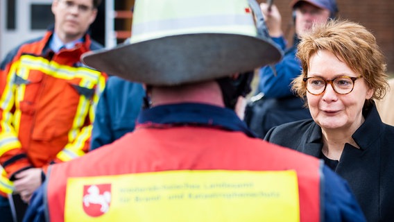 Interior Minister Daniela Behrens (SPD) speaks to a firefighter during her inaugural visit to the NLBK.  © picture alliance/dpa |  Moritz Frankenberg Photo: Moritz Frankenberg