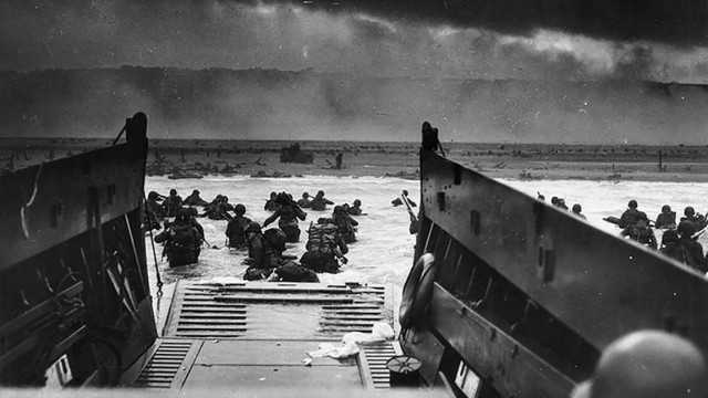 Reise nach England und Frankreich: Ein Bild vom 6. Juni 1944 zeigt US-Soldaten, die am Omaha Beach an Land waten.