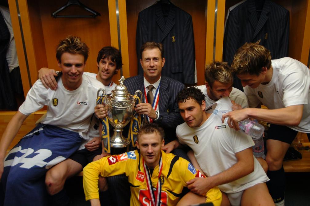 (Anthony Le Tallec, Jérémie Bréchet, Dusko Tosic, Philippe Brunel and Walter Birsa encircle their coach, Alain Perrin, after the victory in the Coupe de France final against Marseille (2-2, 5-4 on pens), May 12 2007./B. Fablet / The Team)