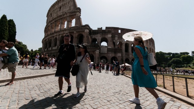 Heat wave in Europe: A woman protects herself with a parasol in front of the Colosseum in Rome.