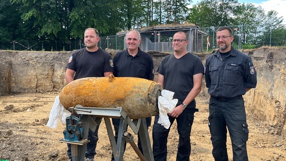 Experts from the explosive ordnance clearance service pose in front of the camera with the defused aerial bomb in Kiel.  © NDR Photo: Christian Nagel