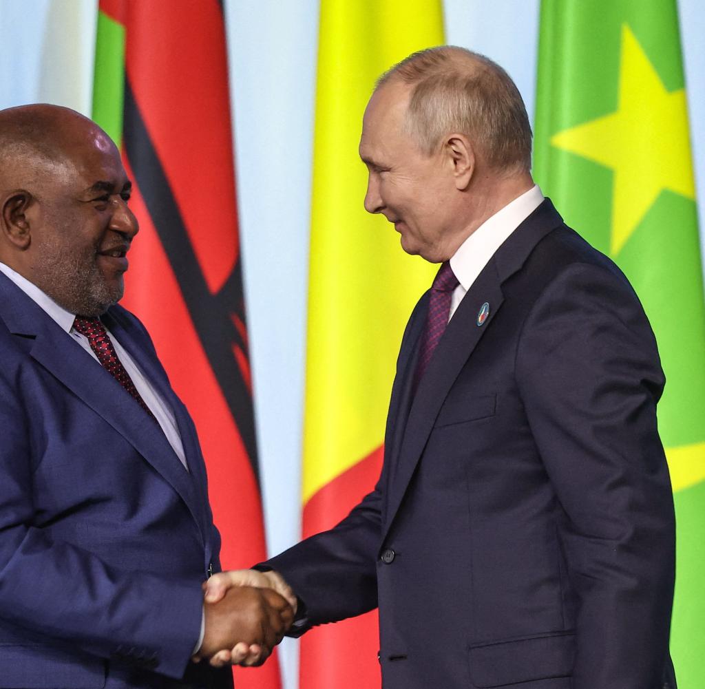 AU-Vorsitzender Azali Assoumani (l) greift beim Russland-Afrika-Gipfel die Hand Russlands Präsidenten Wladimir Putins (r)