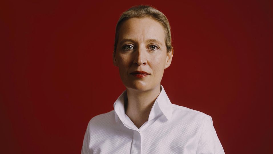 Alice Weidel stands in front of a wall and looks into the camera