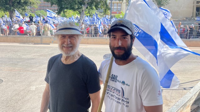 Israel: 89-year-old Avner Itai, with his son next to him, goes to the protests almost every week.  He urges unions to get more involved.