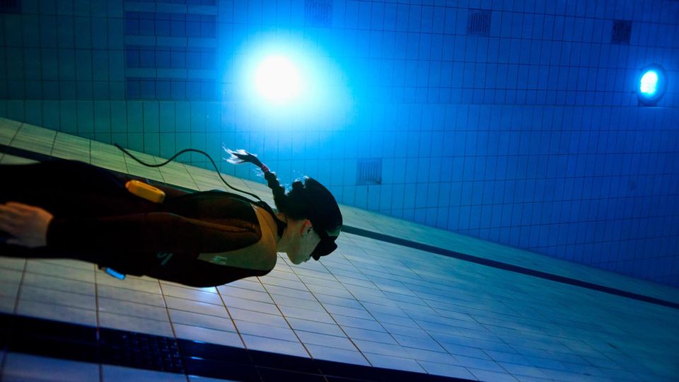 Apnoe Taucherin schwimmt am Boden eines Schwimmbades