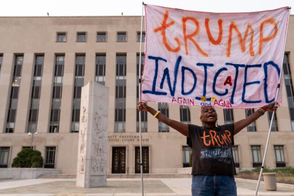 Eine Demonstrierende protestiert mit einem Transparent "Trump angeklagt" vor dem US-Bundesgericht. 