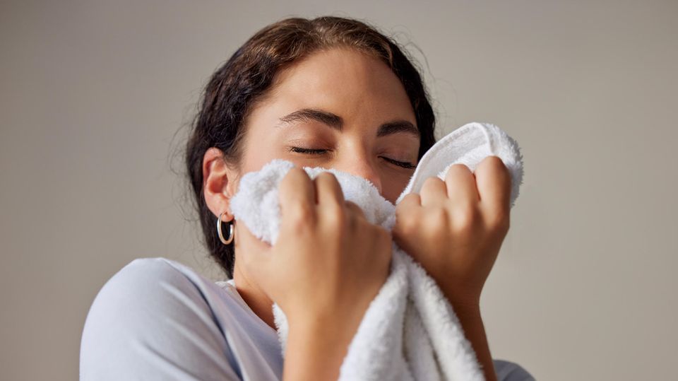 Loss of smell after Corona: A woman smells a towel