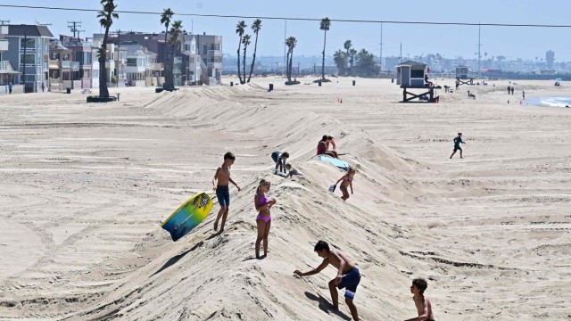 Pacific Region: Children are still playing on a sand wall in Seal Beach, California, on Friday.  It was built to protect houses.